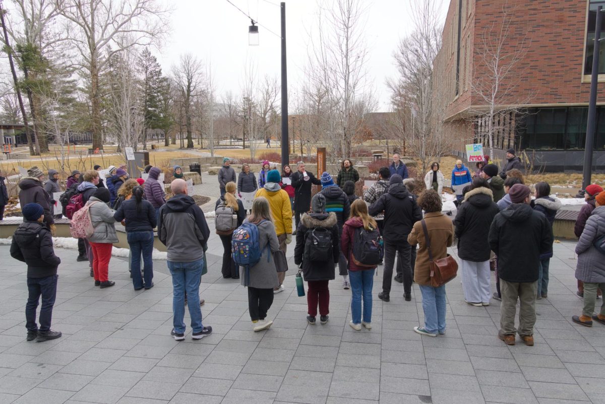 Students and faculty watch Professor David Harrison speak about the importance of defending science in Kington Plaza on Friday, Mar. 7.