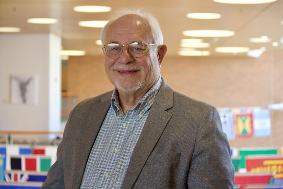 Lyle Muller, professional adviser to The S&B, poses on the second floor of the JRC, where the College's publications room is located.